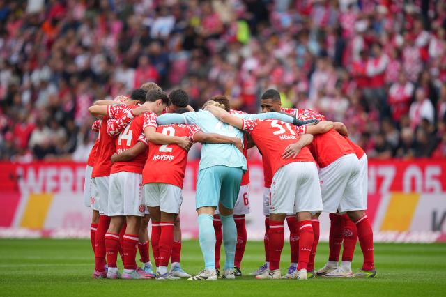 Players of Mainz 05 enter a huddle prior to the Bundesliga match between Mainz 05 and RB Leipzig