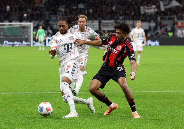 Bayern Munich's Michael Olise takes on Eintracht Frankfurt's Nathaniel Brown.