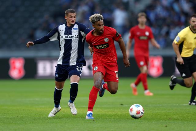Bambase Conte of SV Elversberg is challenged by Michael Cuisance of Hertha BSC