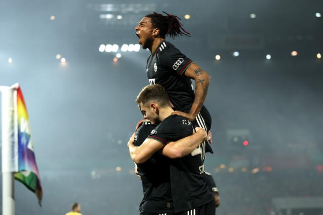 Harry Kane of FC Bayern Munich celebrates scoring his team's second goal with teammates Michael Olise and Josip Stanisic