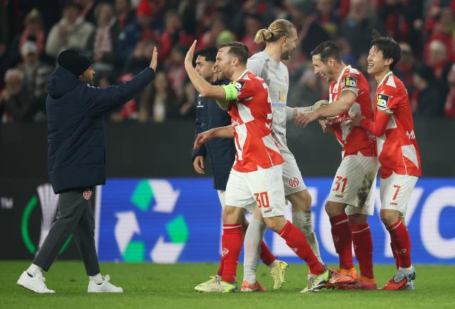 Silvan Widmer of Mainz 05 celebrates with teammates following the team's victory vs. Fiorentina 