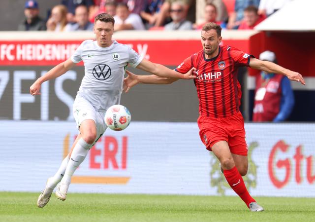 1. FC Heidenheim 1846's Benedikt Gimber competes with VfL Wolfsburg's Dženan Pejčinović, 23. August 2025.
