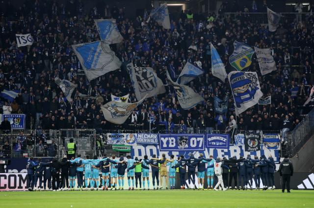 Hoffenheim players and fans celebrating together after beating Frankfurt 3-1.