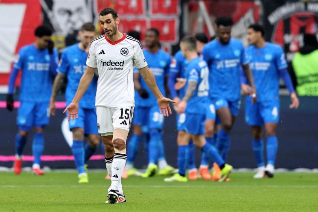 Leverkusen players celebrating with Frankfurt's Ellyes Skhiri being annoyed.