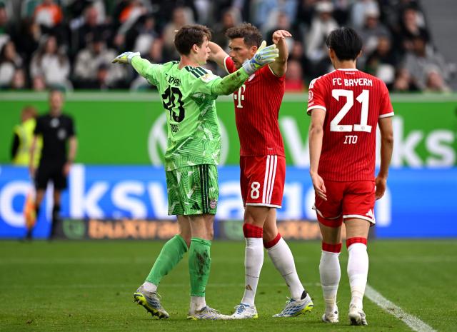 Jonas Urbig of Bayern celebrates with teammates following their victory in Wolfsburg 