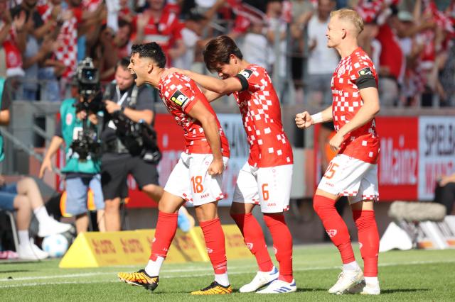 Kaishu Sano (center) backs up teammate Nadiem Amiri (left) in a Mainz match earlier this season.